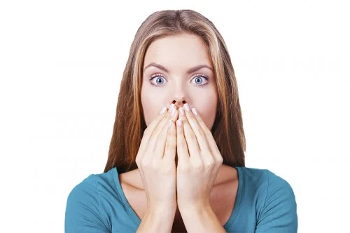 scared woman covering her mouth