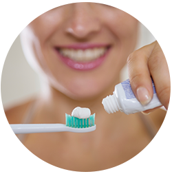 woman applying thoothpaste to brush